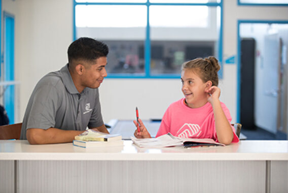 A BGCSC member receives help with her homework at an after-school program